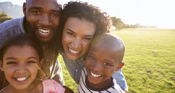 Portrait of a smiling black family outdoors, close up